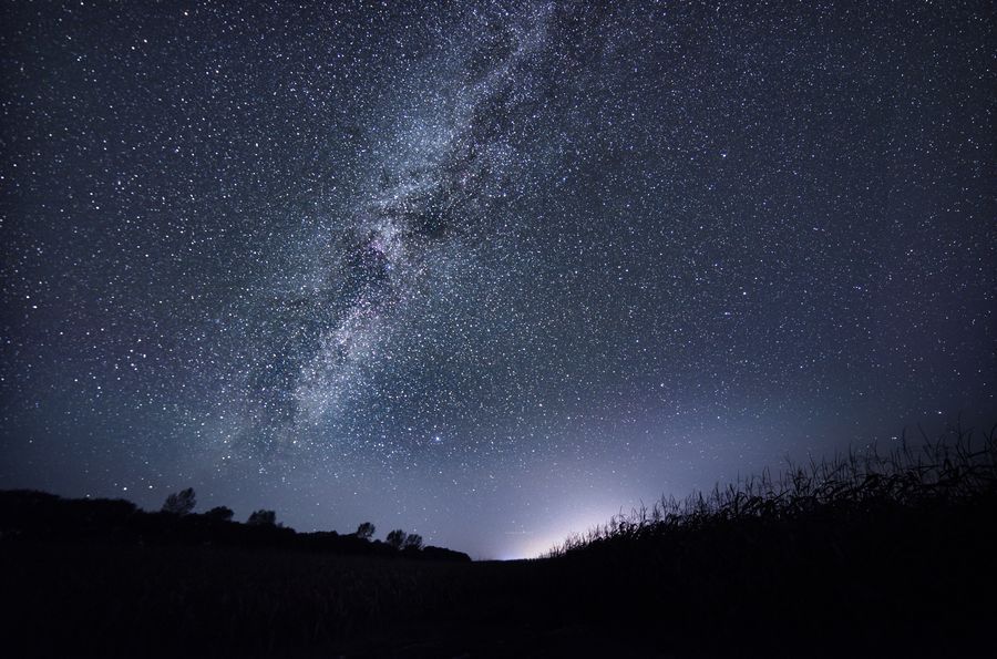 哈拉海镇的夜空，银河自地平线斜升，低空有一抹淡淡的光晕