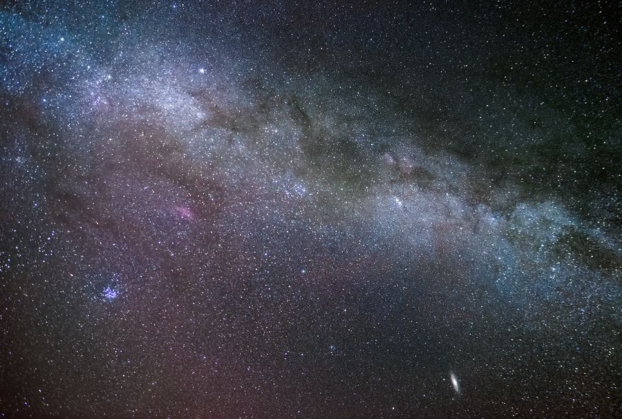 银河横贯整幅画面，星点密集，低空渐隐在地平线的微光里