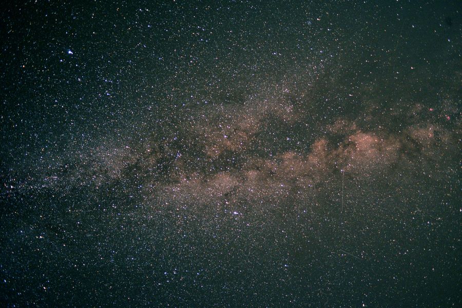 银河纵贯画面，星点细密，暗尘带呈条带状铺开